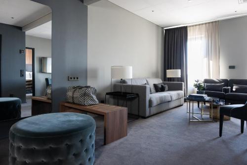 a living room with a couch and a chair at KUST Hotell & SPA in Piteå