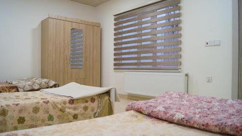 a hospital room with two beds and a window at Besan Motel in As Sulaymānīyah