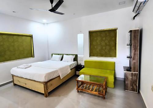 Shivansh Cottage Diveagar في دايف إيغار: غرفة نوم بسرير وكرسي أخضر