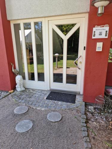 a front door of a house with glass doors at Residence Moai - Exklusiver Rückzugsort für Geschäftsreisen - kostenloser Parkplatz, WLAN, Waschtrockner, Smart TV, Qbo ESSENTIAL, ergonomischer Schreibtisch in Erlangen