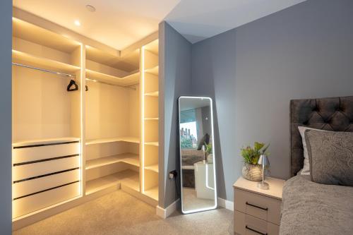 a bedroom with a walk in closet and a mirror at City Centre Luxury Apartment In Deansgate in Manchester