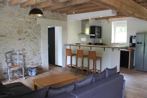 un salon avec un canapé et une cuisine dans l'établissement 2h Paris, nature et quiétude, Chez Armantine, à Saint-Georges-sur-la-Prée