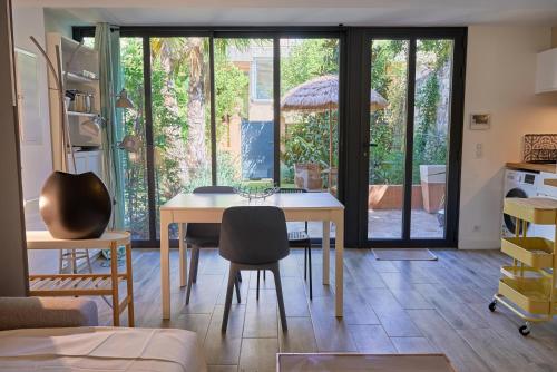 d'une salle à manger avec une table, des chaises et des portes coulissantes en verre. dans l'établissement Villa d'Architecte, Jardin Secret & Plages à 5 Min, à Toulon