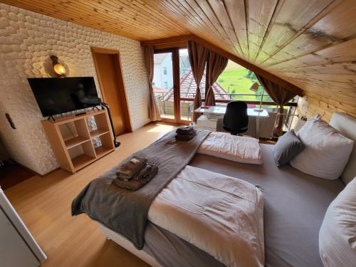 a large bedroom with two beds and a flat screen tv at Hotel Schönblick in Bad Herrenalb