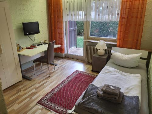 a bedroom with a bed and a desk with a computer at Hotel Schönblick in Bad Herrenalb