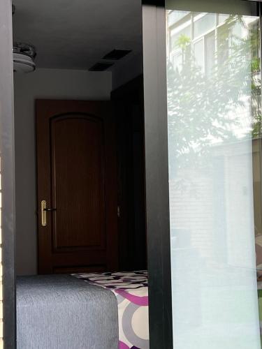 a room with a bed and a door and a window at El BC Zaragoza - Aljafería in Zaragoza