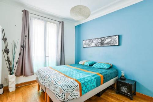 une chambre bleue avec un lit et une fenêtre dans l'établissement Superb T2 bien équipé proche du Canal Saint-Martin, à Paris