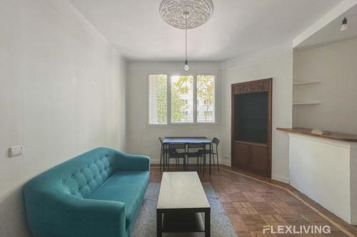 un salon avec un canapé bleu et une table dans l'établissement Flexliving - whole flat - Verdun, à Paris
