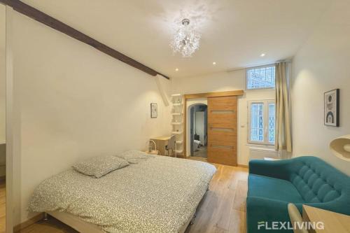 une chambre avec un lit et un canapé bleu dans l'établissement Flexliving - studio - Lemoine, à Paris