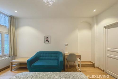 un salon avec un canapé bleu et une table dans l'établissement Flexliving - studio - Lemoine, à Paris