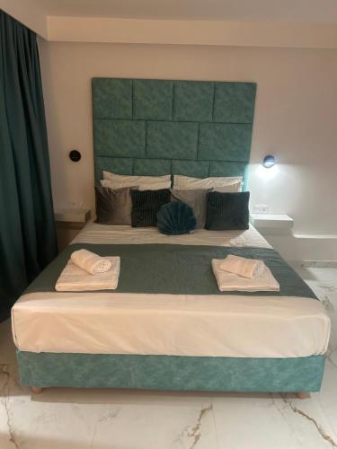 a bedroom with a large bed with two towels on it at Marilouiz in Kalamata