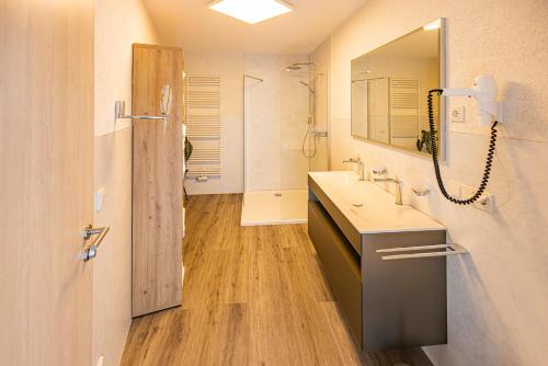 a bathroom with a sink and a mirror at Business Vital Hotel am Rennsteig in Suhl