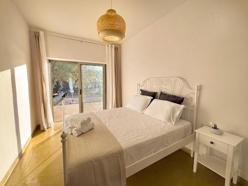 a bedroom with a white bed and a window at Mekia's beach house in Livadia