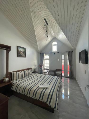 a bedroom with a large bed with a white ceiling at Lovely House in Da Lat