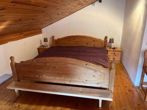 a large wooden bed in a room with wooden floors at Chata Na Podhorčí in Frýdštejn