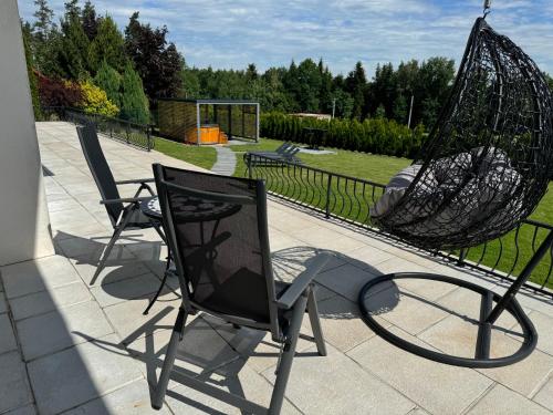 two chairs and an umbrella on a patio at Willa pod Lanckoroną in Izdebnik