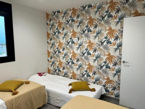two beds in a room with a wallpaper at Appartement VillaCosta in Orihuela