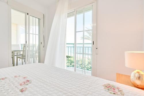 a white bedroom with a bed and a balcony at Strand Appartement Met Zwembad Td04 in Torrox