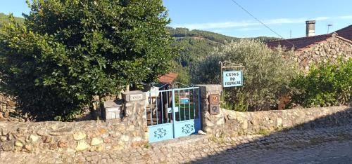 a stone fence with a gate in front of a house at Casas do Favacal in Penela