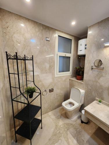 a bathroom with a toilet and a sink at Modern 2-Bedroom Apartment in Cairo