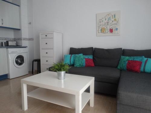 sala de estar con sofá y mesa en Málaga Apartamentos - Refino, 36, en Málaga
