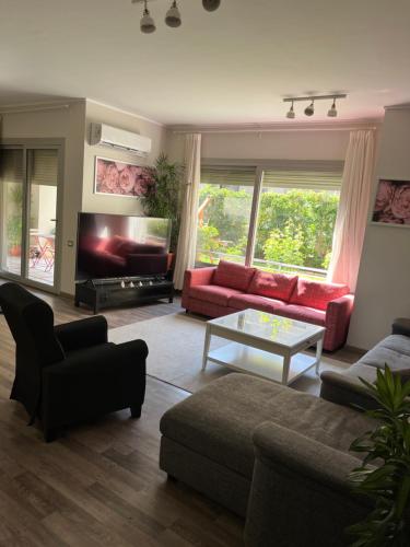 a living room with a red couch and a table at Modern 2-Bedroom Apartment in Cairo