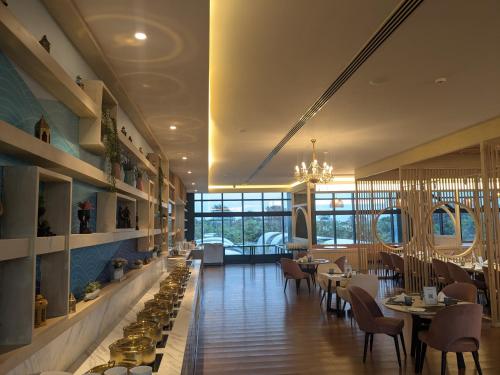 um restaurante com mesas e cadeiras e um lustre em Fortune Beach Resort ECR, Chennai - Member ITC Hotels' Group em Chennai