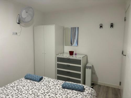 a bedroom with a bed and a dresser and a mirror at Capuchos Terrasse in Caparica