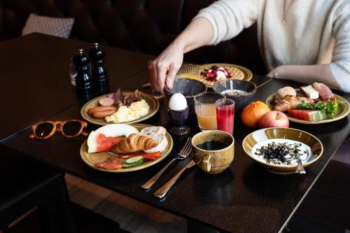 a table with plates of food on a table at KUST Hotell & SPA in Piteå