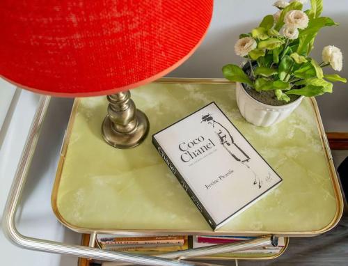 a book on a table with a lamp and a plant at 6 Riverside Apart Sleeps 5 NEC 7mins BHX 8mins in Coleshill