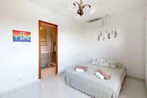 une chambre blanche avec un lit et une pancarte sur le mur dans l'établissement Villa Unicorn à Antibes, à Antibes