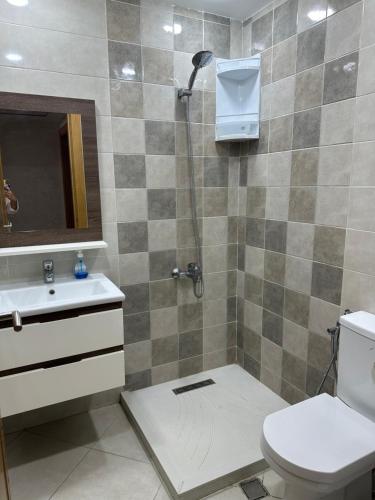 a bathroom with a shower with a toilet and a sink at Appartement océan amirat only family in Martil