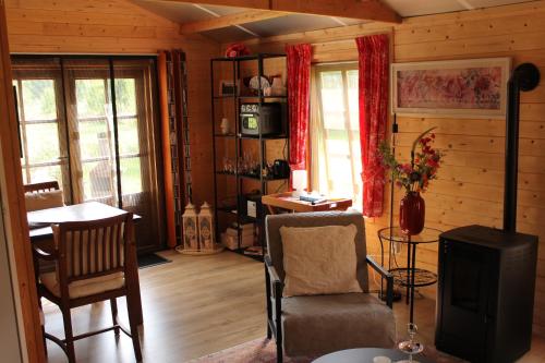 a living room with a fireplace and a table and chairs at Natuurhuisje in het weiland in Topweer