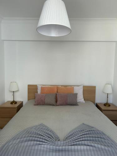 a bedroom with a large bed with two lamps at Apartamento Batalha - Quarteira, Algarve, Portugal in Quarteira
