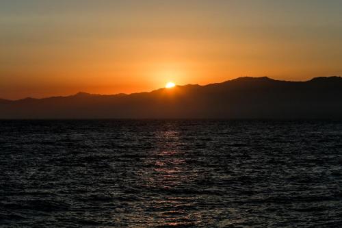 a sunset over the ocean with mountains in the background at Ocean Park Hotel in Los Angeles
