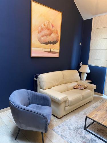 a living room with a couch and a chair at Les Sansonnets in Vaux-sur-Sûre