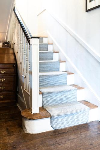 a stairway with blue and white stairs with a wooden floor at Lancrigg in Grasmere