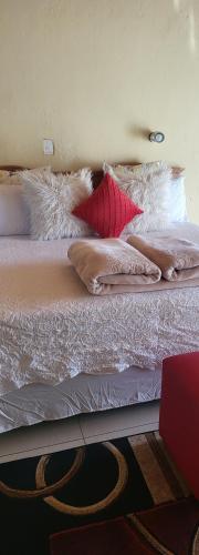 a bed with many pillows on it in a room at Skyline Guest House in Mahikeng