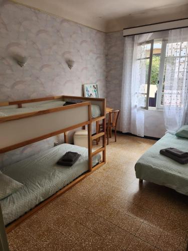 une chambre avec deux lits superposés et une table dans l'établissement Agréable maison de ville, à Thuir