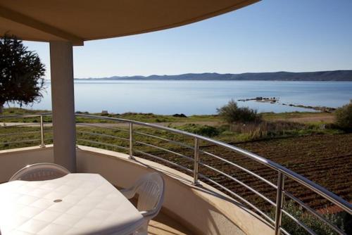 balcón con mesa, sillas y vistas al lago en Apartment in Sukosan/Zadar Riviera 8087, en Sukošan