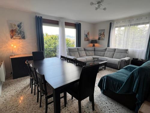 un salon avec une table et un canapé dans l'établissement Appartement calme avec jardin dans maison, à Le Poët