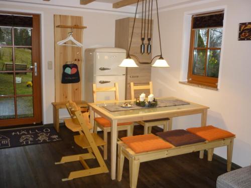 a kitchen with a table and chairs and a refrigerator at Ferienwohnung Lämpelberg in Klingenthal