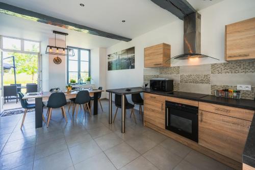 a kitchen with a table and a dining room at Les gîtes Saint-Aignan in Saint-Aignan