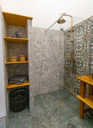 a shower with a glass door in a bathroom at Farm Lodges Olive, Casa Bougainvillea in Moncarapacho