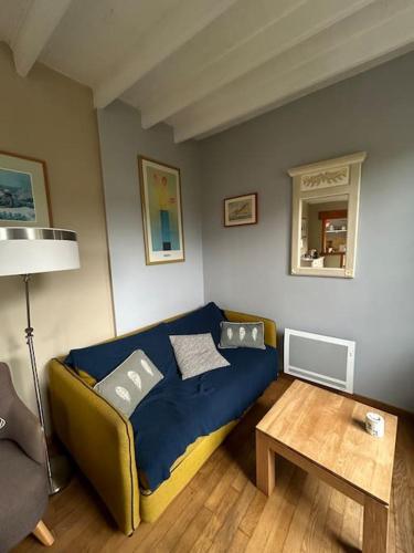 un salon avec un canapé et une table dans l'établissement Maison à 50 m de la plage, à Saint-Jean-le-Thomas