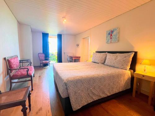 a bedroom with a large bed and two chairs at La Vigneronne, Chailly-Montreux in Montreux