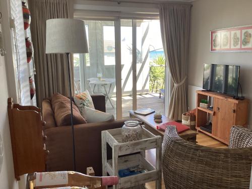 a living room with a couch and a television at Chez James in Yzerfontein
