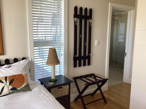 a bedroom with a bed and a lamp on a table at Chez James in Yzerfontein