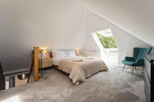 a bedroom with a bed and a green chair at Coastal Garden Retreats in Poole