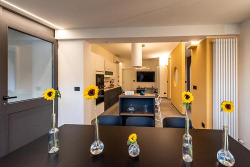 a room with a table with flowers in vases on it at Maison Hublot in Chiavari
